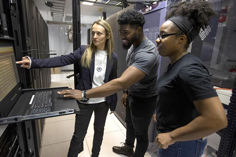 students in control room with faculty member